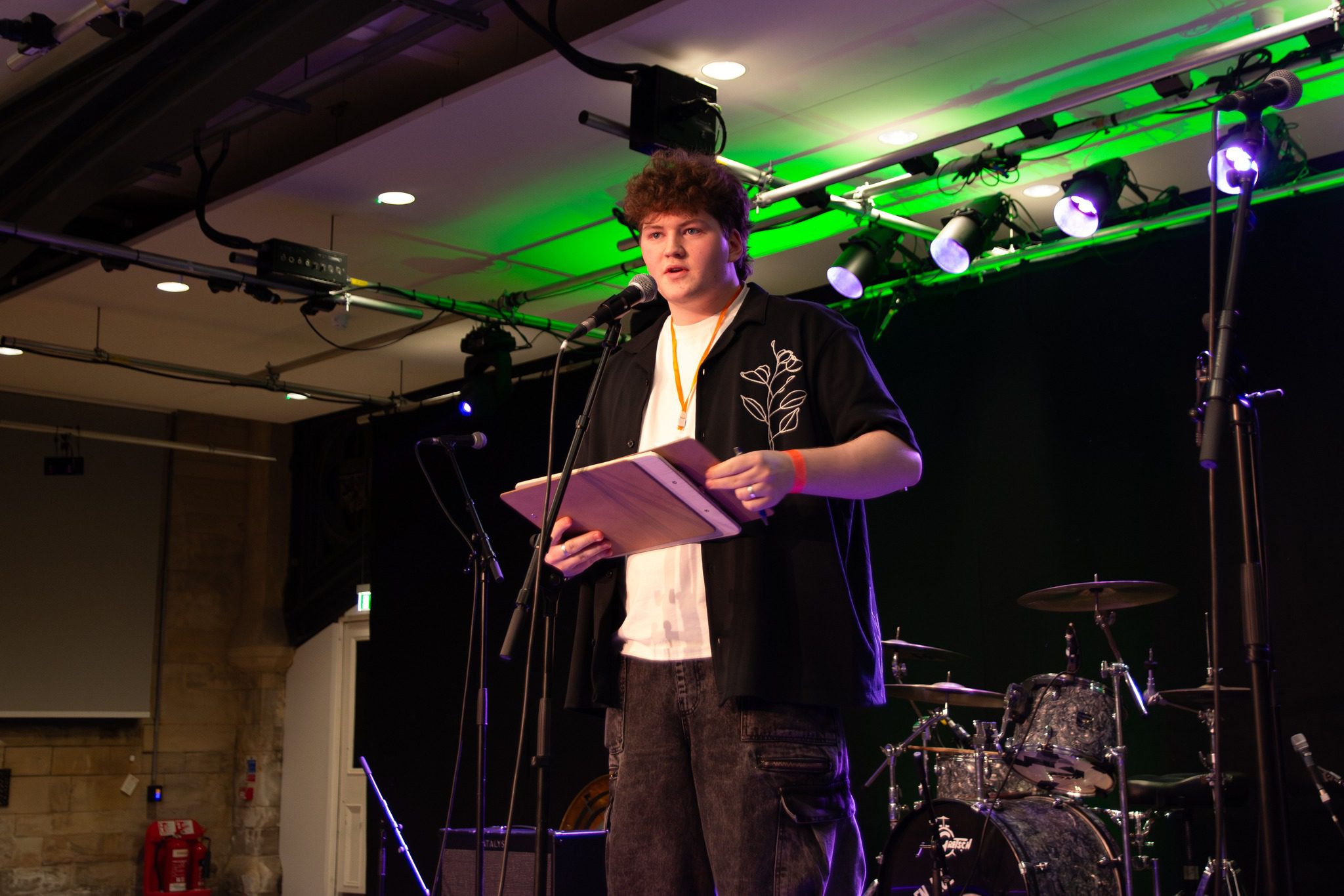 A young person speaking into a mic on a stage