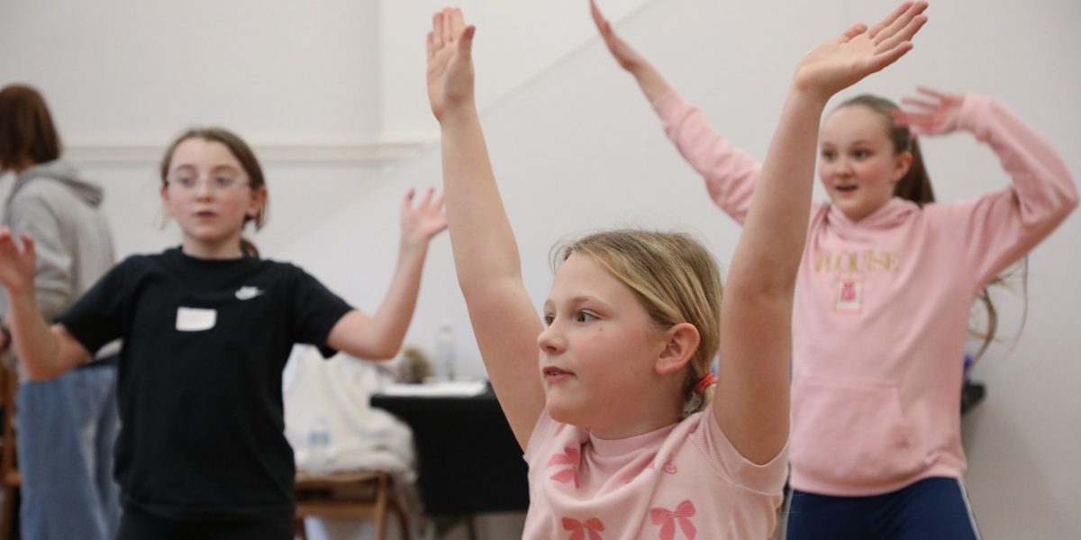 Young people raising their arms during a dance class