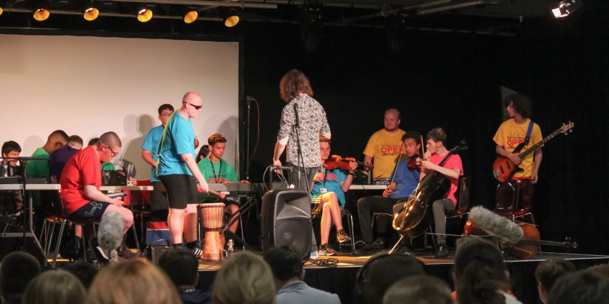 An orchestra of young people performing on stage