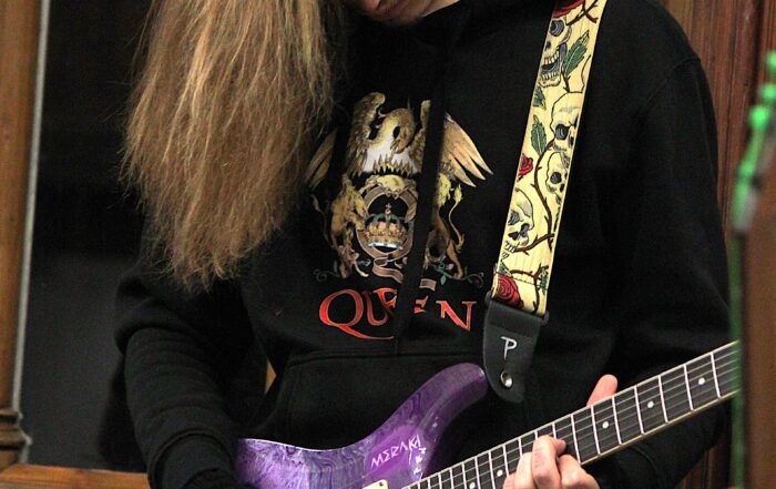 A young person playing the electric guitar