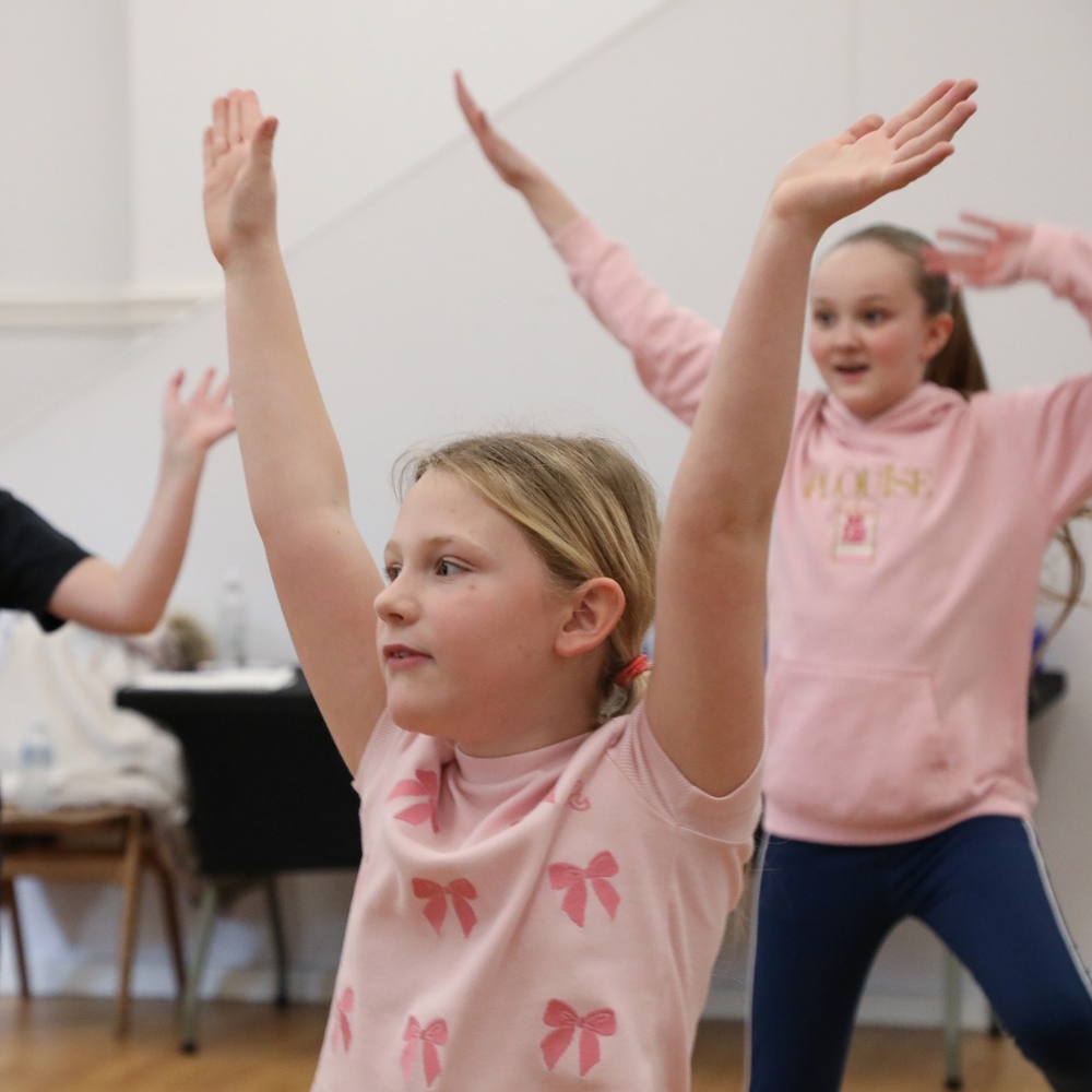 media policy Children raising their hands during a dance class