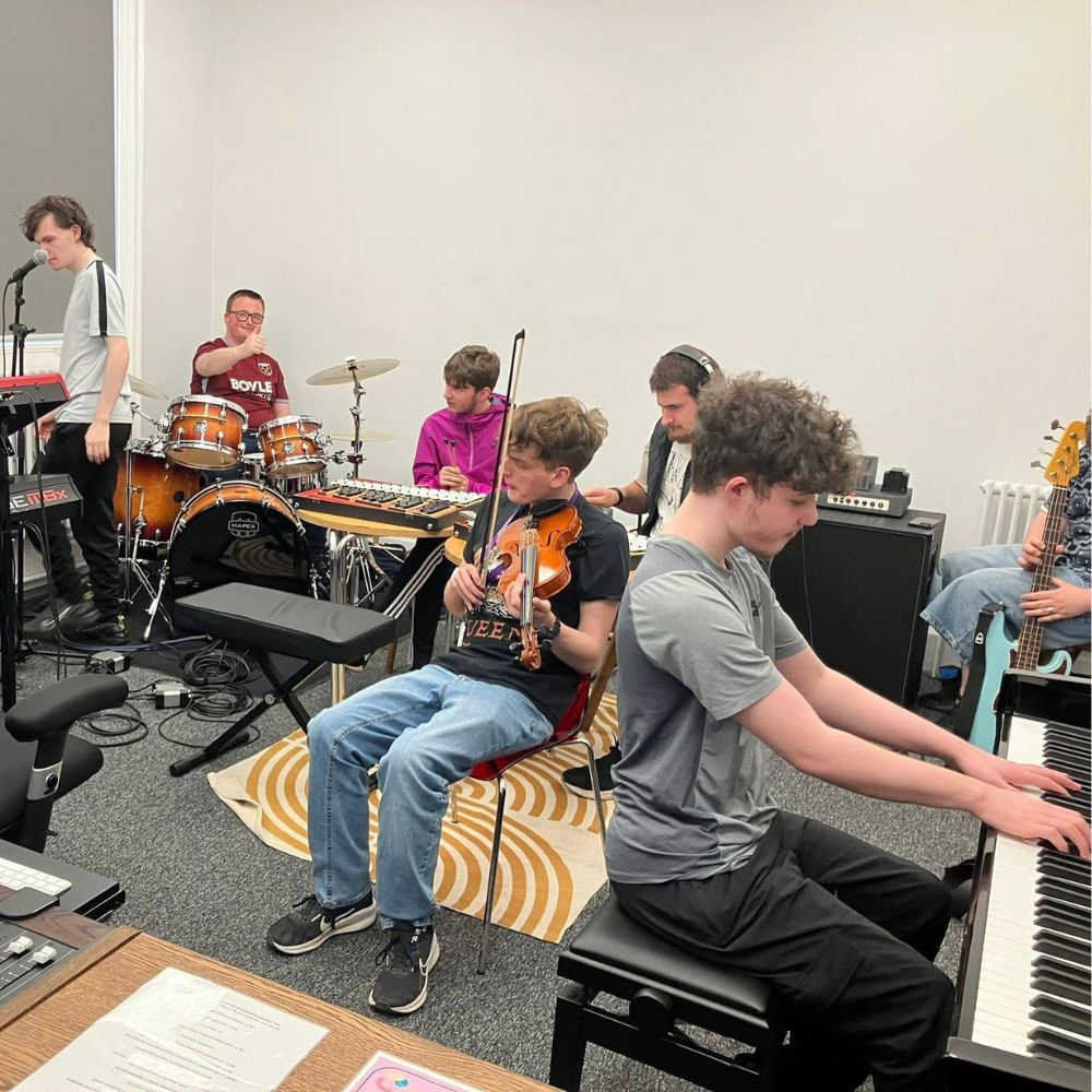 The Lost Orchestra using the rehearsal space a group of young people playing various instruments in a studio space