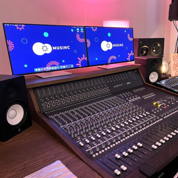 Rehearsal and Recording Studio a recording desk with speakers and two screens with the Musinc logo