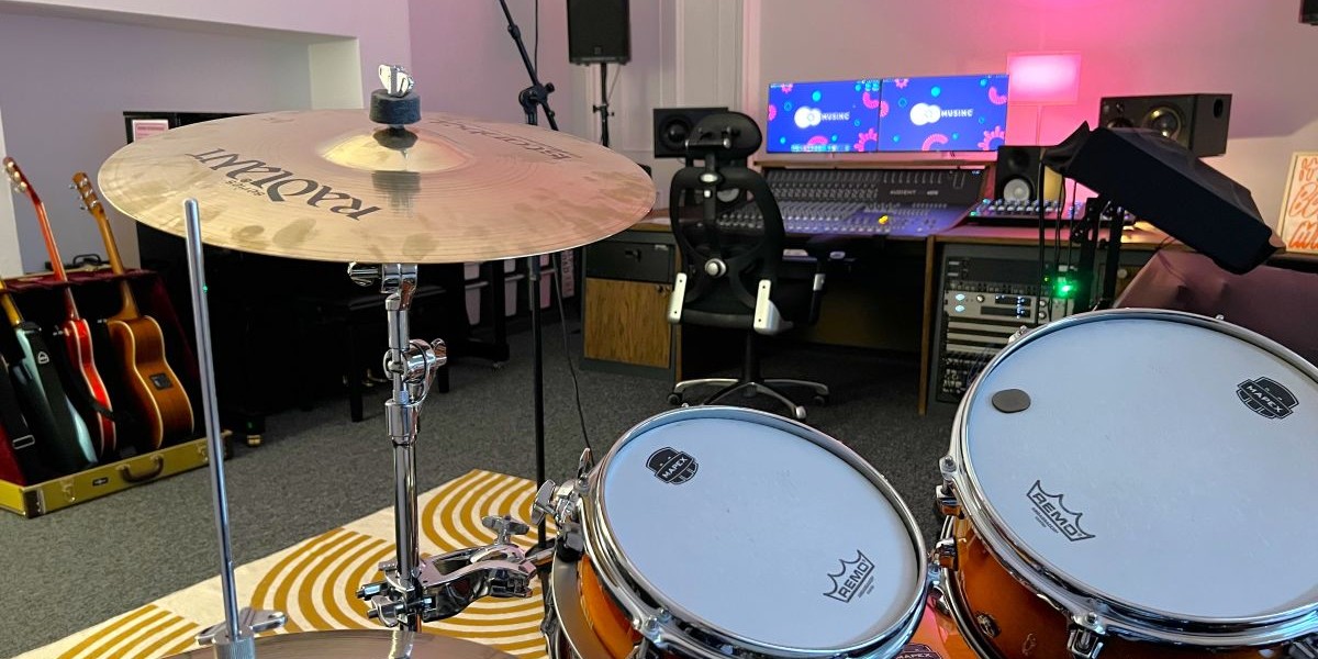 A recording studio with various musical instruments and a desktop computer