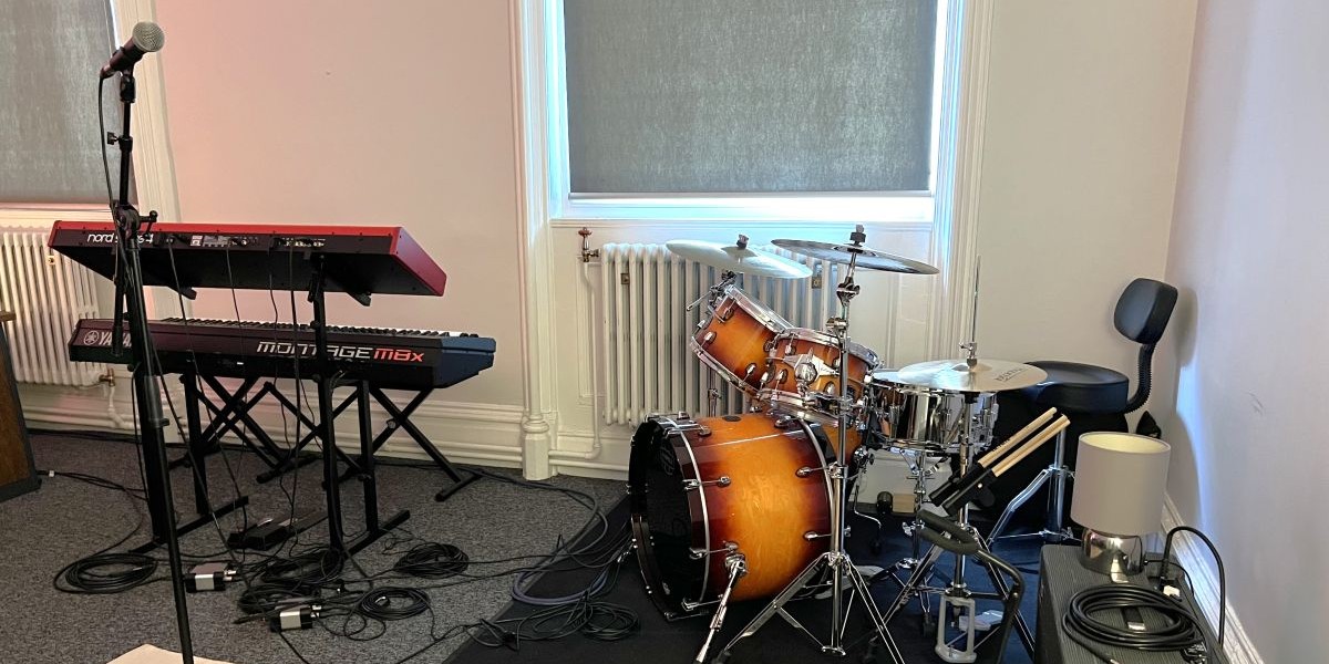 A recording studio with various musical instruments and a desktop computer