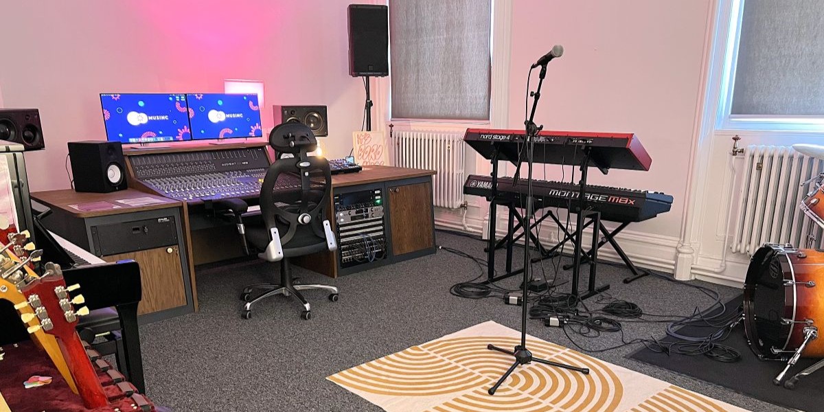 A recording studio with various musical instruments and a desktop computer