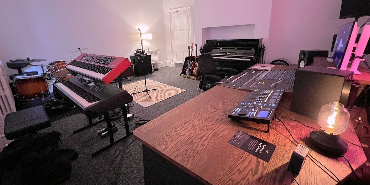 A recording studio with various musical instruments and a desktop computer